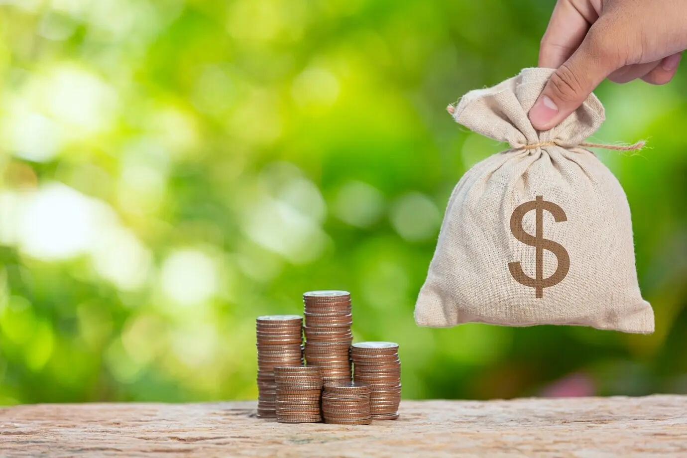 Día Mundial del Hábitat, foto en primer plano de una pila de monedas y un saco con monedas